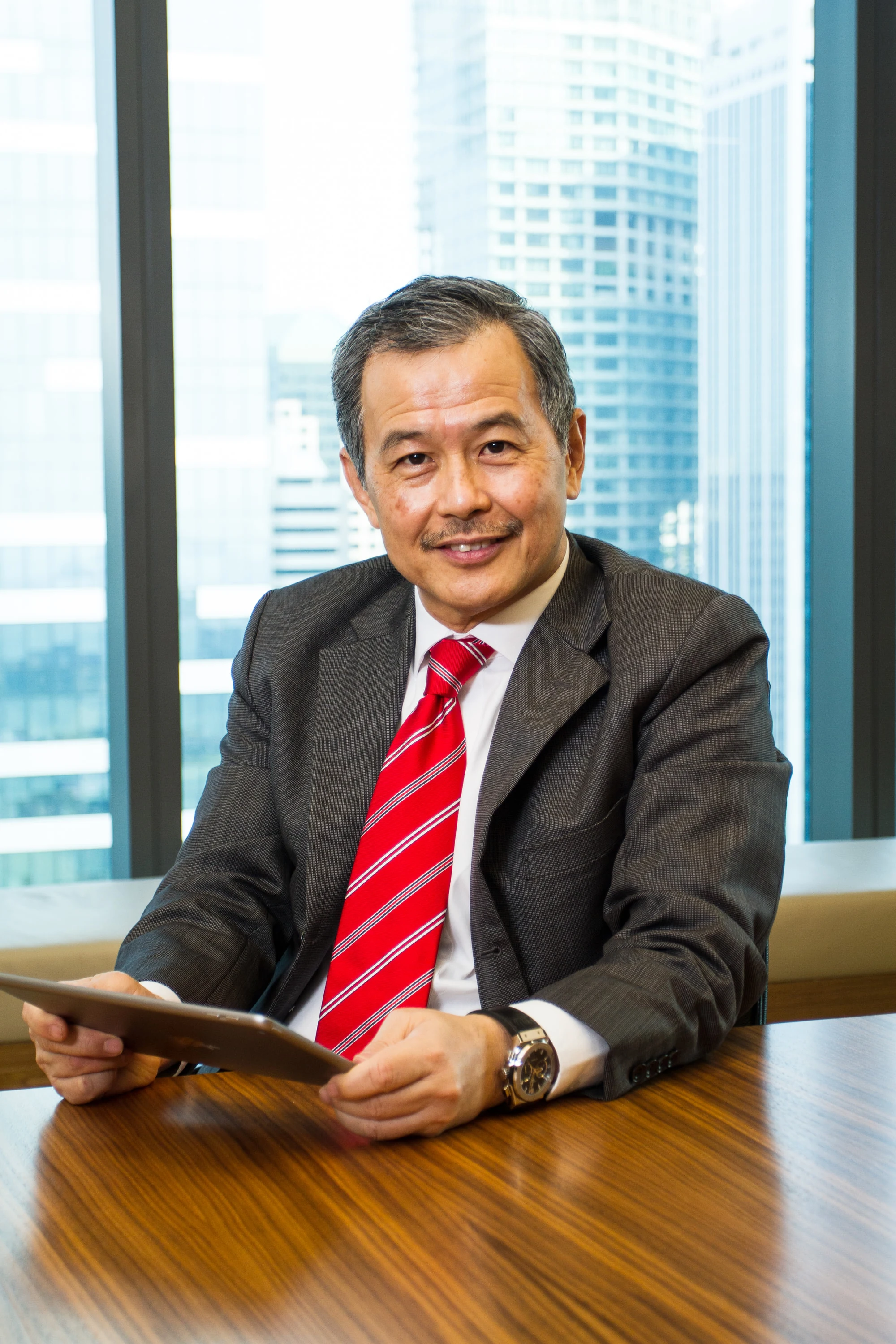 Business executive seated with a tablet in a Singapore office