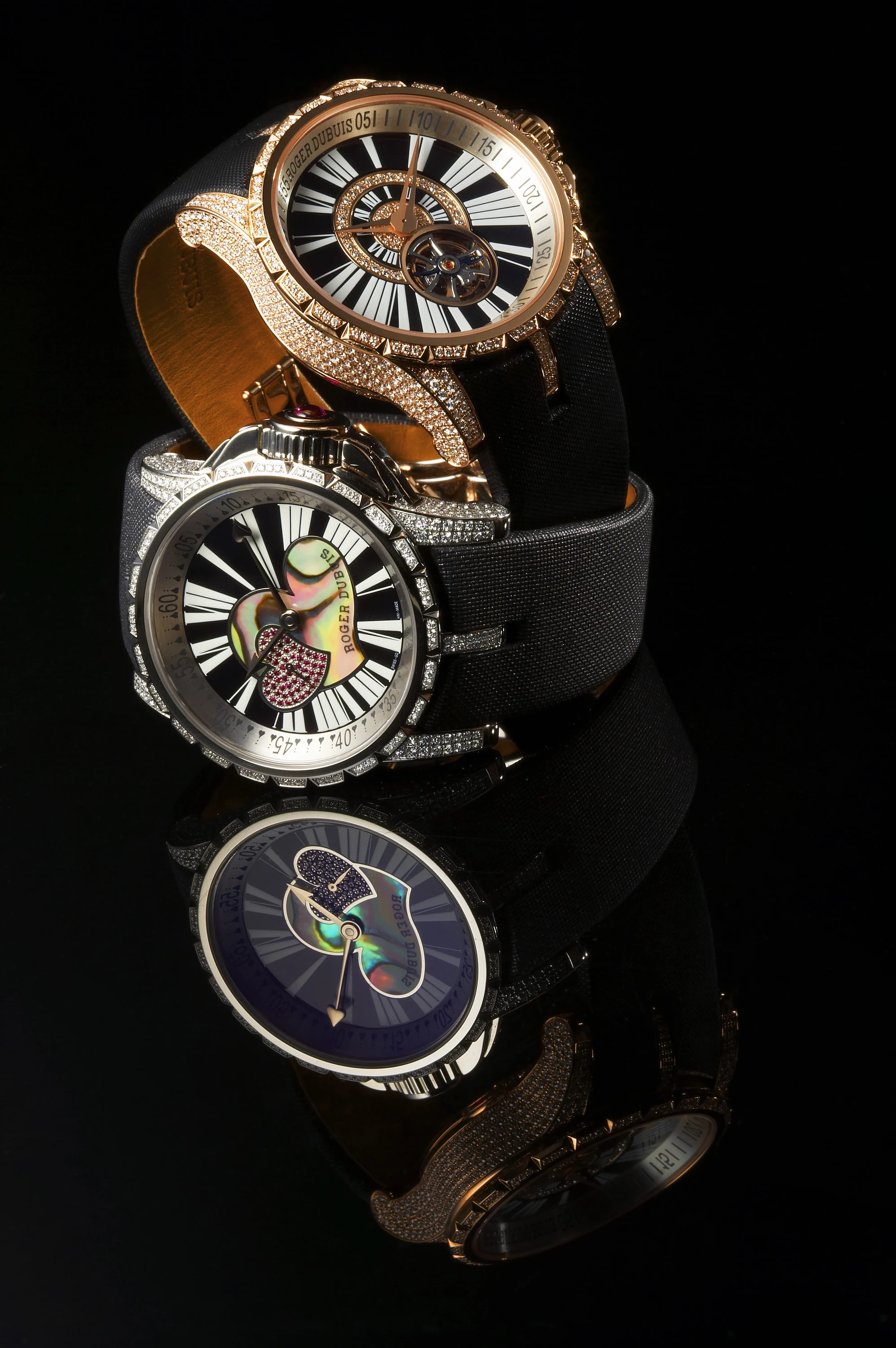 Two diamond-set watches arranged on black fabric with reflections