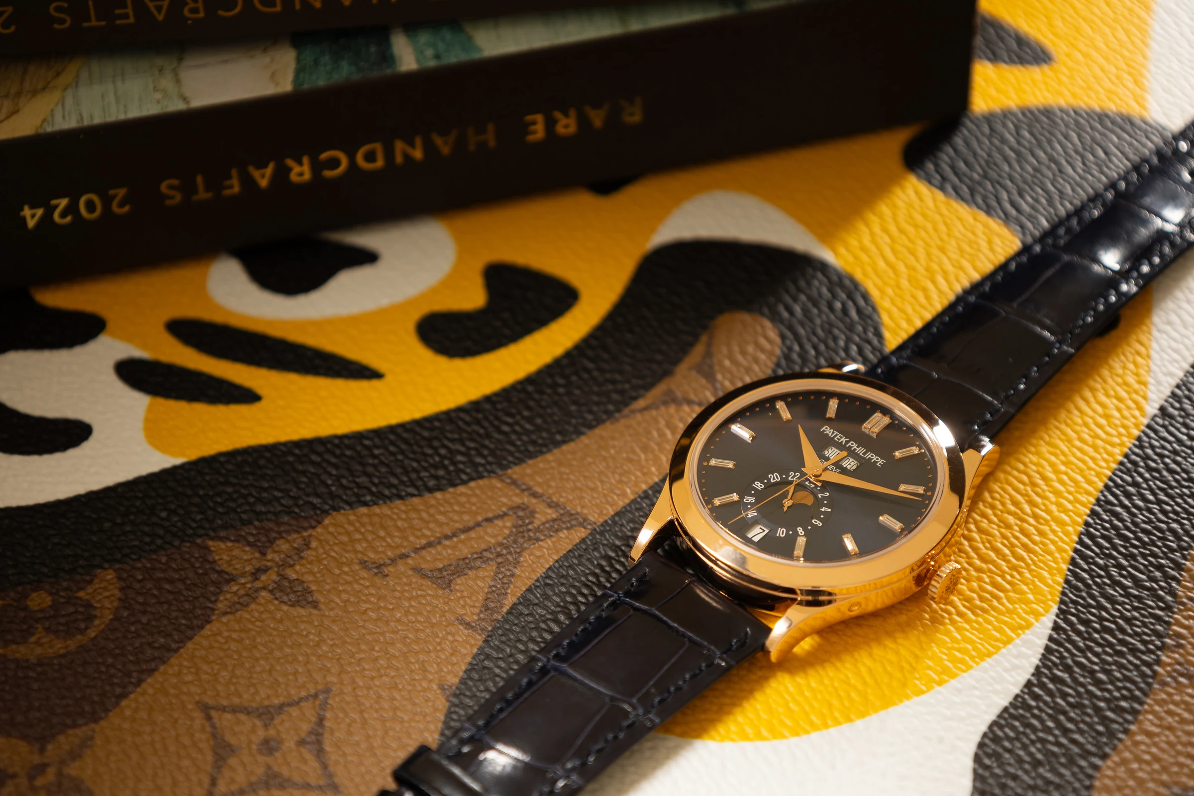 Gold wristwatch styled on a yellow graphic leather background