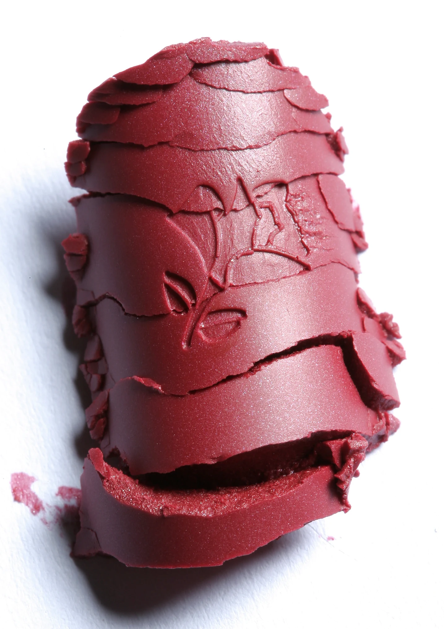 Sculpted red lipstick texture with an embossed face